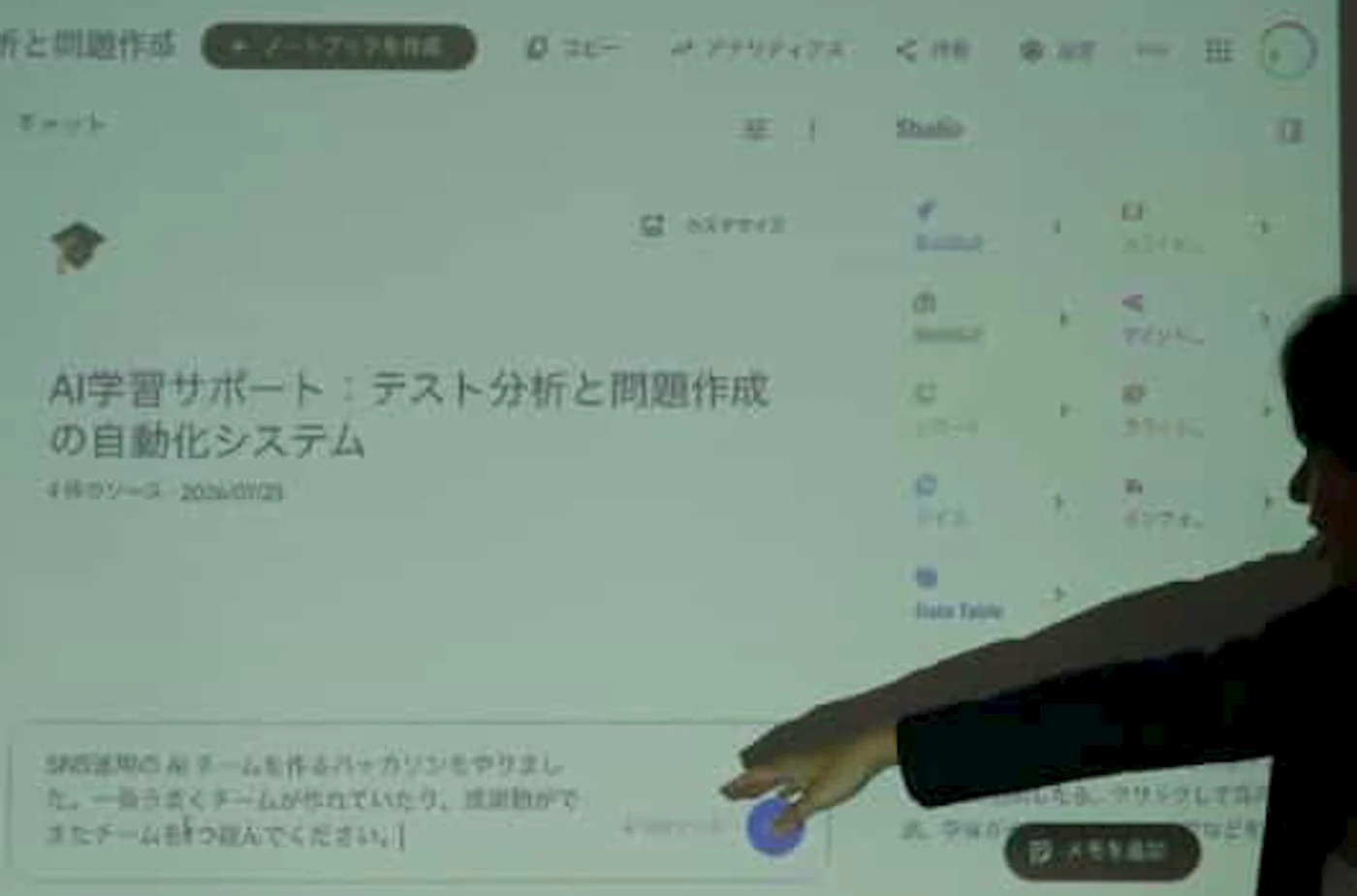 プロジェクターに映したGemini Notebookの画面。4個のソースに対してプロンプトを入力しているところ